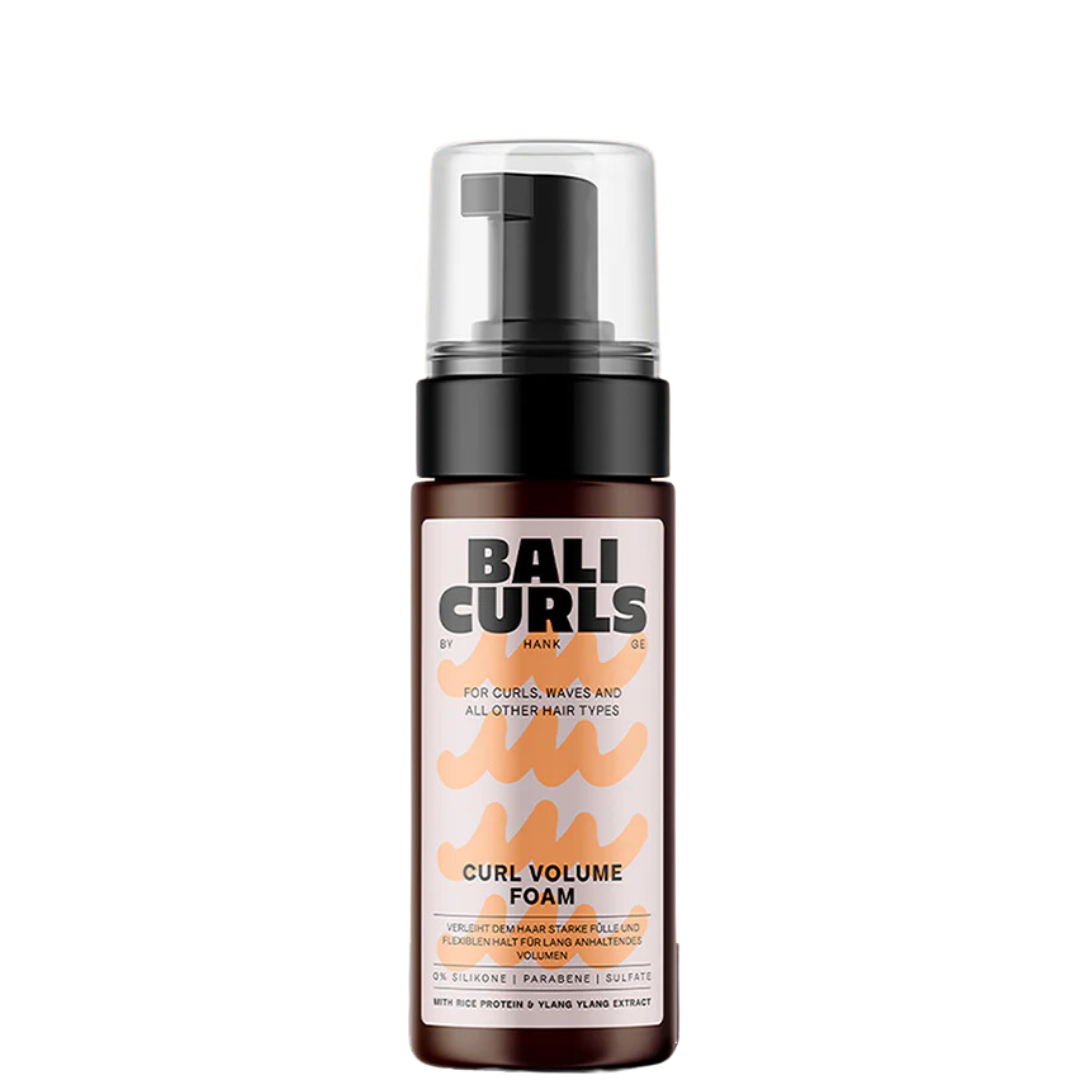 Bali Curls Curl Volume Foam 150ml (FULL-SIZE) wordt geleverd in een fles met een pompdispenser en heeft etiketdetails in oranje en zwarte tekst. Deze styling foam is doordrenkt met proteïnen om het krulvolume en de definitie te verbeteren voor prachtig veerkrachtig haar.